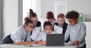 Kids working together on a computer while learning perseverance and problem solving