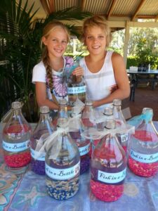 Kids selling fish in a bottle at a market stall as part of real family enterprise stories and a creative business idea