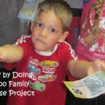 Chayse holding a fifty dollar note for the $100 Family Enterprise Project