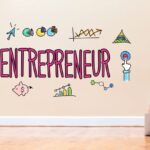 Child using a laptop with entrepreneur ideas on the wall for raising enterprising kids