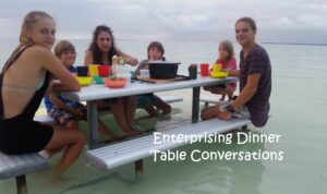 Family having dinner at a picnic table in shallow water on the Cocos Islands