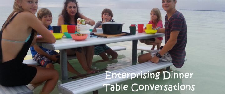 Family having dinner at a picnic table in shallow water on the Cocos Islands