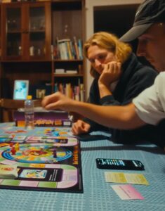 Family members gathered around a table playing Cashflow 101