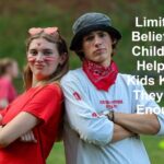 Kit as a young adult standing confidently with folded arms while working as a summer camp facilitator and team leader